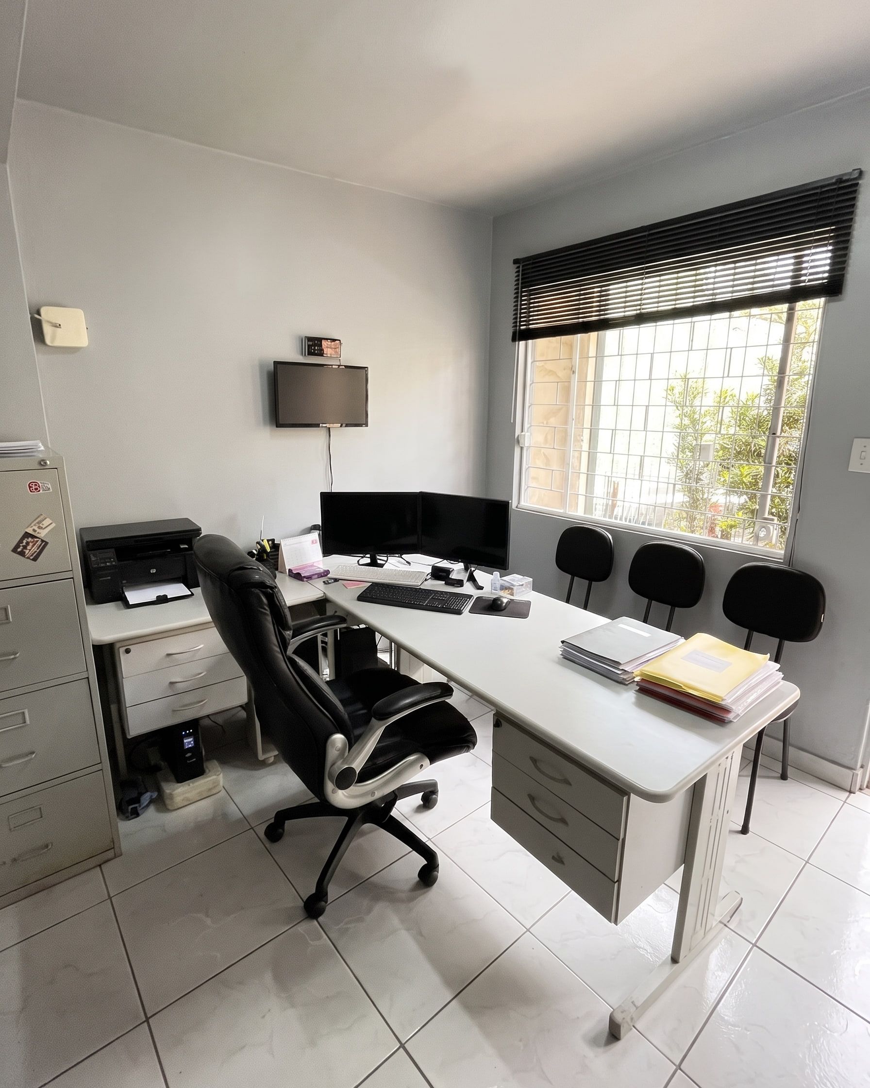 Sala de atendimento da Nepack Assessoria, com mesa em L, cadeiras para visitantes e janela com luz natural